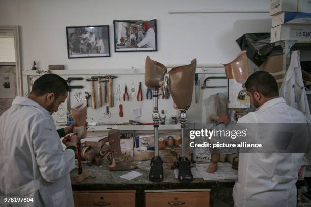 Staff members of Gaza's Artificial Limbs and Polio Centre prepare prosthetic legs, in Gaza City, 22 April 2018. The ALPC was established in 1974 and...