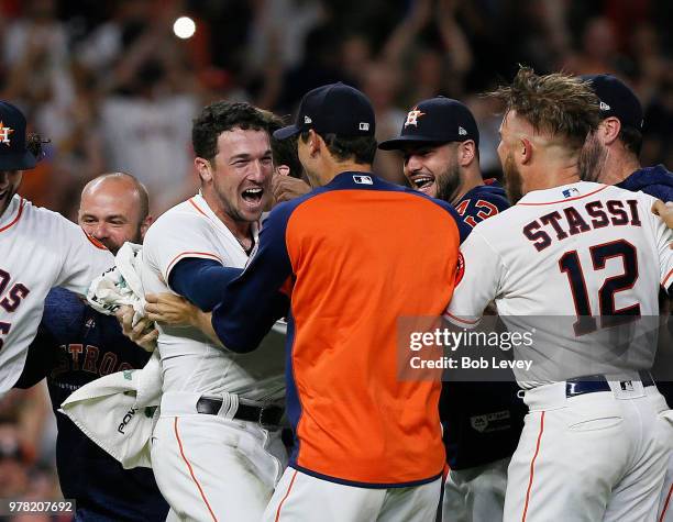 Alex Bregman of the Houston Astros is mobbed by his teammates after hitting a walkoff double in the ninth inning against the Tampa Bay Rays for a 5-4...