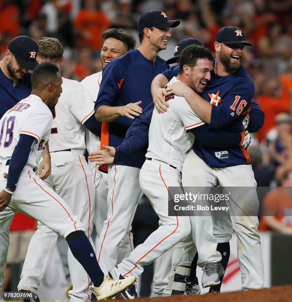 Alex Bregman of the Houston Astros is mobbed by his teammates after hitting a walkoff double in the ninth inning against the Tampa Bay Rays for a 5-4...