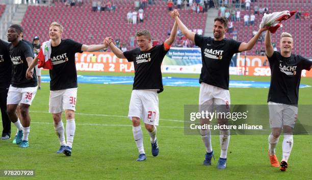 April 2018, Germany, Augsburg: soccer, Bundesliga, FC Augsburg - FSV Mainz 05, WWK-Arena. Wearing shirts reading "Obacht" , Augsburg's Kevin Danso ,...