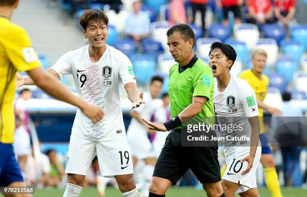 Kim Young-gwon and Lee Seung-woo of South Korea contest the decision of referee Joel Aguilar of Salvador during the 2018 FIFA World Cup Russia group...