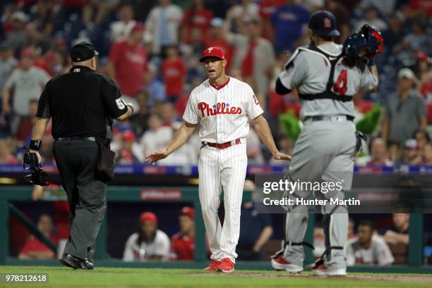 Manager Gabe Kapler of the Philadelphia Phillies speaks with home plate umpire Eric Cooper about challenging a call on a home run ball that landed in...