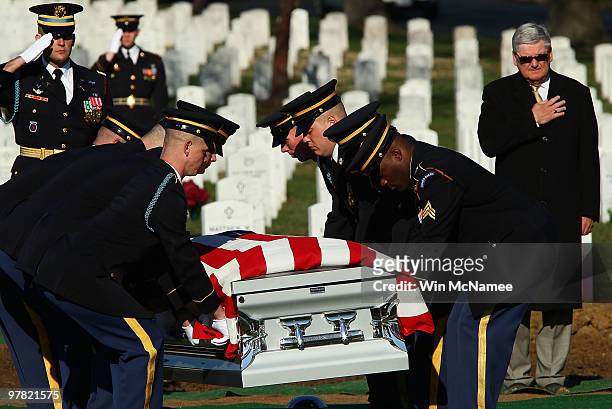 An honor guard team carries the remains of four U.S. Soldiers who died in a helicopter crash in Iraq in 2009 during a group burial service at...