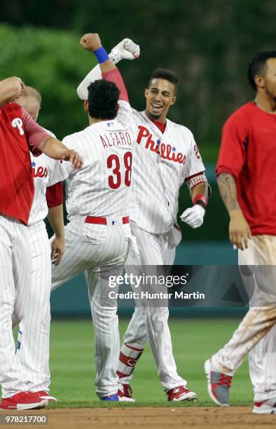 Aaron Altherr of the Philadelphia Phillies celebrates with Jorge Alfaro after hitting a game winning two-run double in the 10th inning during a game...