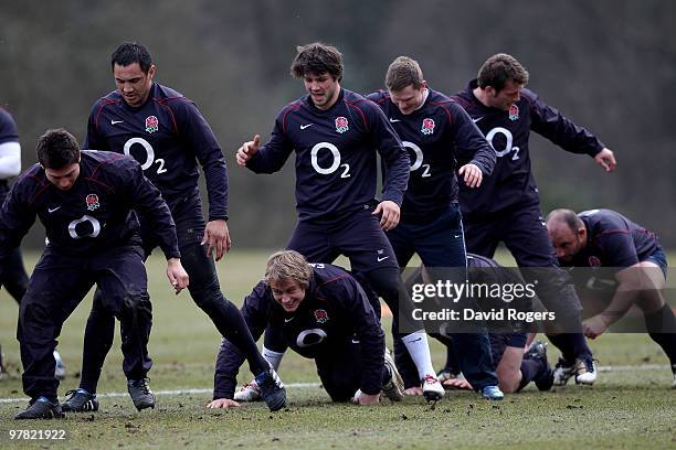 Mathew Tait, crawls through the legs of team mates in the warm up during the England training session held at Pennyhill Park on March 17, 2010 in...