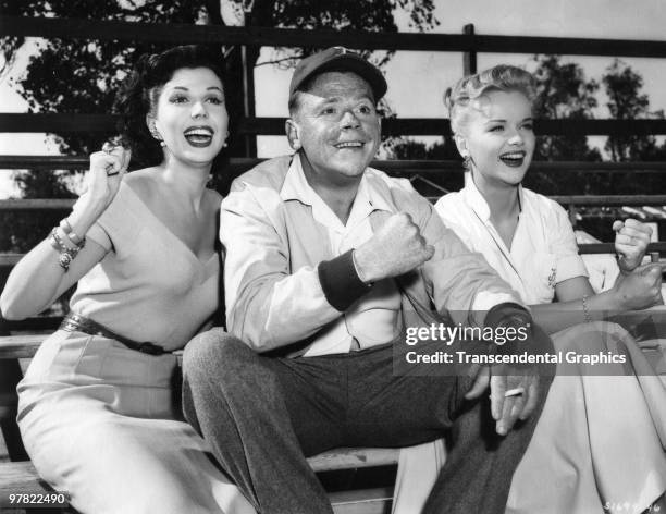 American actors Ann Miller , Tom Ewell , and Anne Francis cheer on their team from the bleachers in a still from 'The Great American Pastime' , 1956.