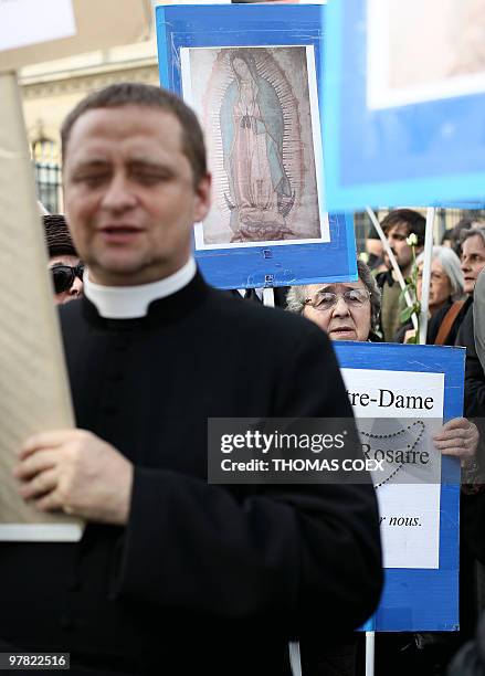 Priest marches with anti-abortion demonstrators who protest on March 18, 2010 in front of the Institute of France in Paris during the welcoming...
