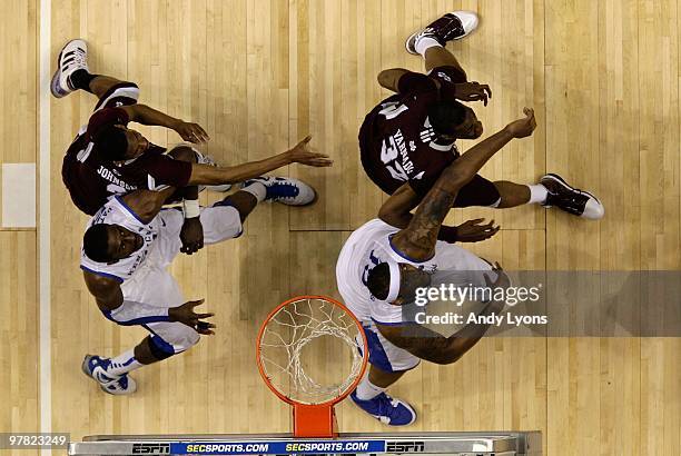 Patrick Patterson and DeMarcus Cousins of the Kentucky Wildcats fight for rebound position against Jarvis Varnado Ravern Johnson of the Mississippi...