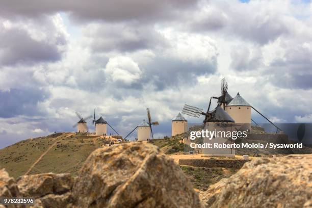 storm clouds on historic windmills of consuegra, don quixote route, toledo province, castile-la mancha region, spain - don quixote stock-fotos und bilder