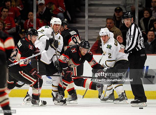 Troy Brouwer and Kris Versteeg of the Chicago Blackhawks chases the puck along with Mike Modano and Nicklas Grossman of the Dallas Stars at the...