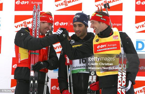 Emil Hegle Svendsen of Norway with race winner Martin Fourcade of France and overall leader Christoph Sumann of Austria celebrate after the men's...
