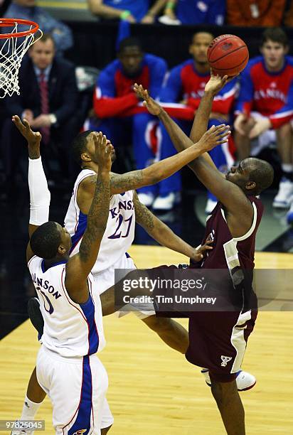 Bryan Davis of the Texas A&M Aggies goes up for a running jump shot over Marcus Morris and Thomas Robinson of the Kansas Jayhawks during the...