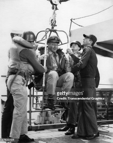 American actor John Wayne is lifted aboard a ship in a scene from 'The Wings of Eagles in 1957. In the film, based on a true story, Wayne plays Frank...