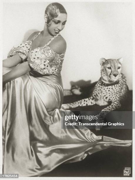 Portrait of American cabaret entertainer Josephine Baker as she sits with her pet cheetah, Chiquita, early 1930s.