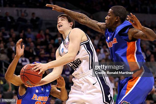 Jimmer Fredette of the BYU Cougars drives for a shot attempt against Kenny Boynton of the Florida Gators during the first round of the 2010 NCAA...