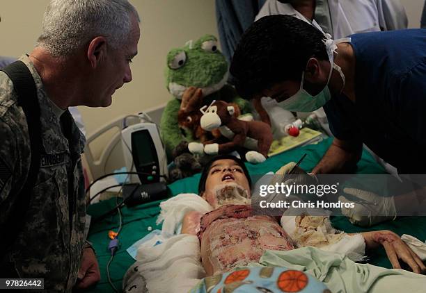 An Afghan nurse removes bandages from the burn wounds of a heavily-sedated Abdul Rahman while Army doctor Lt. Col. Barry Steinberg of Jacksonville,...