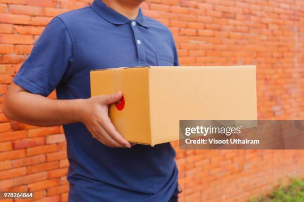 asia delivery man are holding a cardboard box delivery - pack ice stockfoto's en -beelden