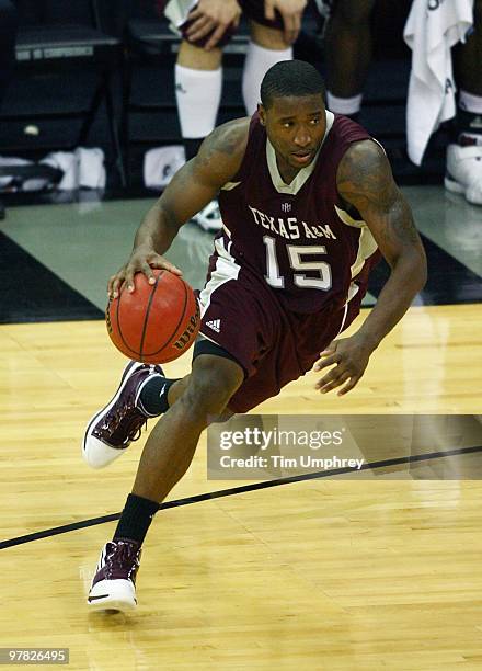 Donald Sloan of the Texas A&M Aggies tries to dribble around the defense of the Kansas Jayhawks during the semifinals of the 2010 Phillips 66 Big 12...