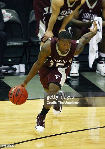 Donald Sloan of the Texas A&M Aggies tries to dribble around the defense of the Kansas Jayhawks during the semifinals of the 2010 Phillips 66 Big 12...