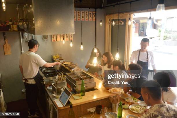 verschiedenen ethnischen freunde genießen ein abendessen im japanischen pub - kitchen bar stock-fotos und bilder