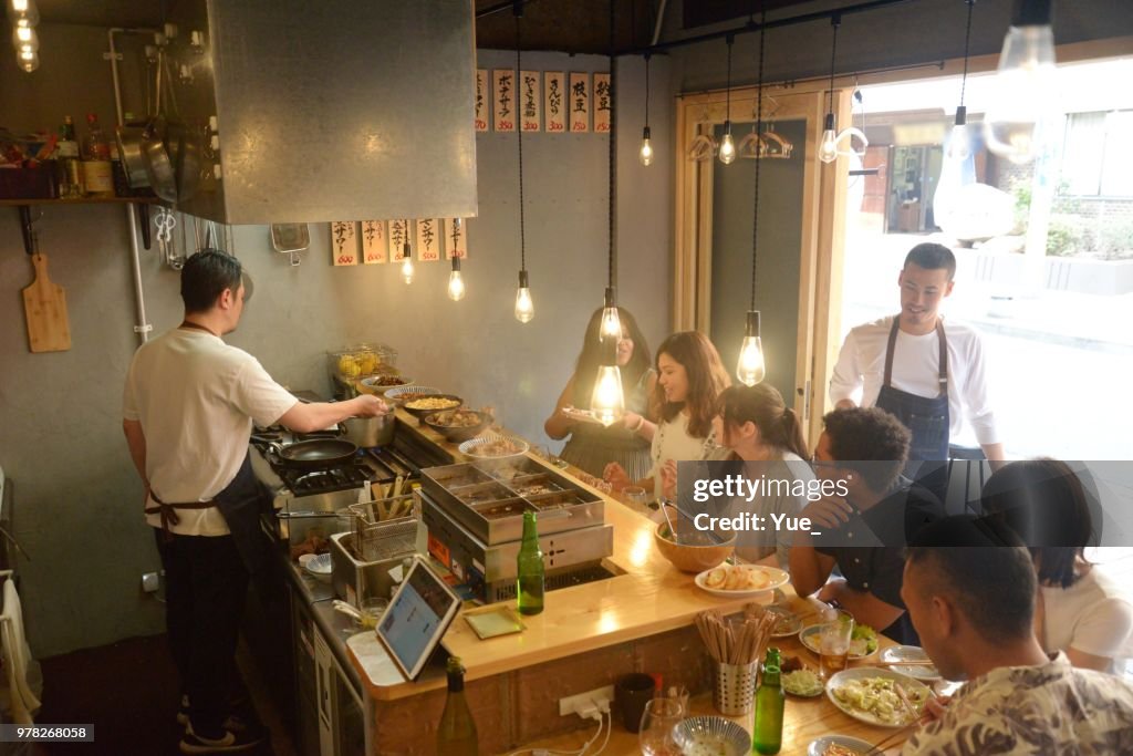 Various ethnic friends enjoying a dinner at Japanese pub