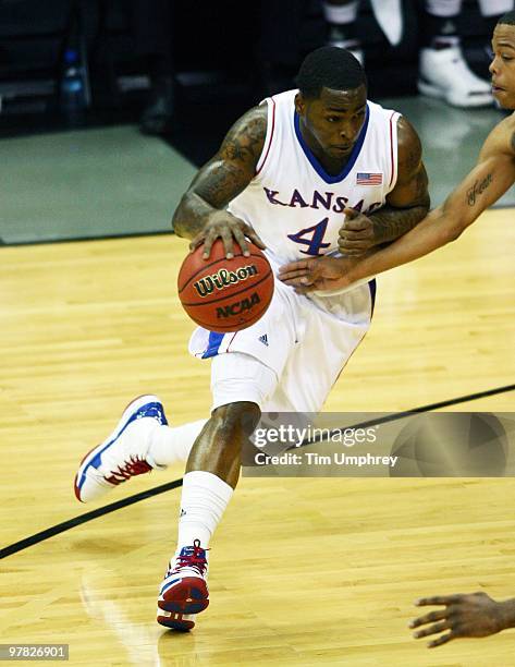 Sherron Collins of the Kansas Jayhawks tries to dribble around the defense of the Texas A&M Aggies during the 2010 Phillips 66 Big 12 Men's...