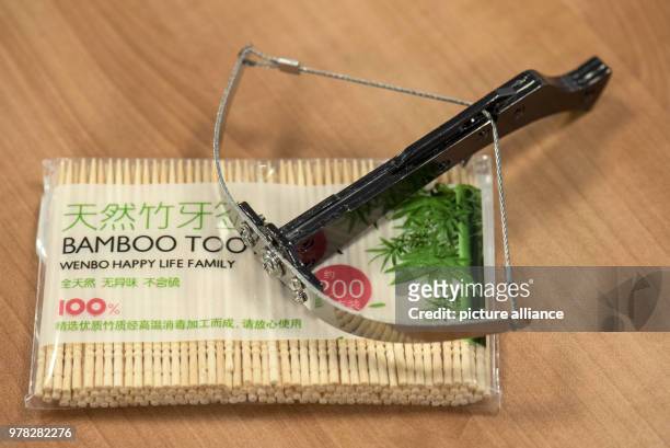 Confiscated miniature crossbow and a packet of toothpicks are seen on display at the customs office's annual press conference in Frankfurt, Germany,...