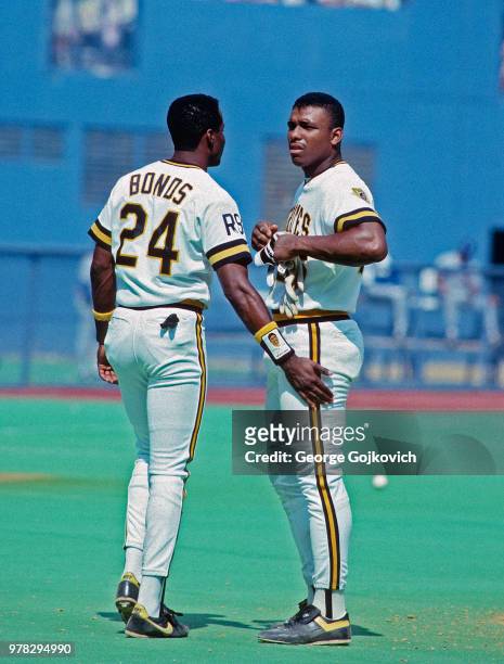 Barry Bonds and Bobby Bonilla of the Pittsburgh Pirates talk between innings of a Major League Baseball game at Three Rivers Stadium circa 1990 in...