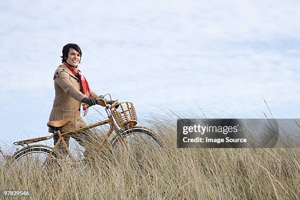 女性のフィールドに自転車 - チャタン ストックフォトと画像