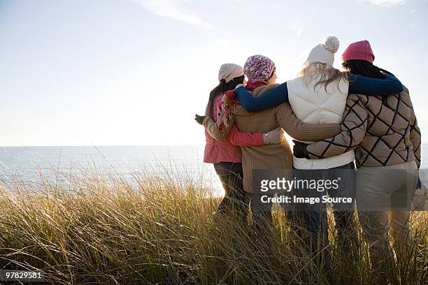 female friends by the sea - female friendship stock pictures, royalty-free photos & images