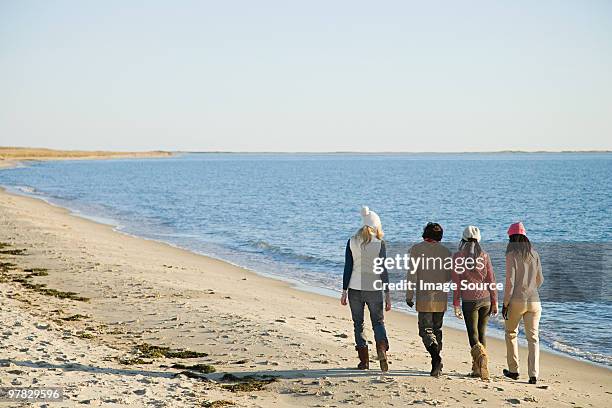 four women walking by sea - autumn friends coats stock pictures, royalty-free photos & images