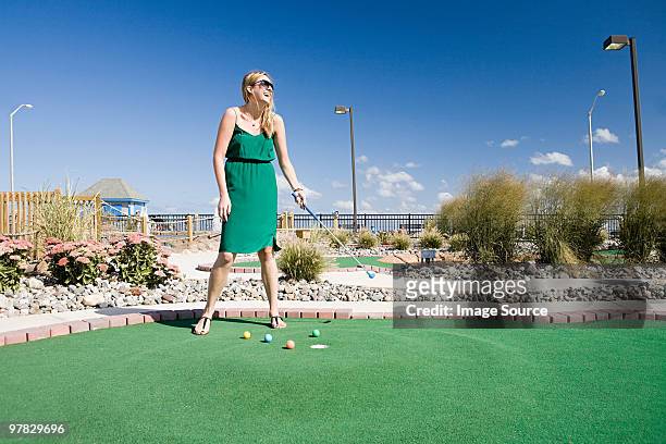 woman playing miniature golf - minigolf foto e immagini stock