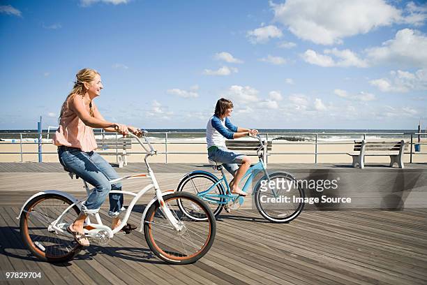 two women cycling on boardwalk - boardwalk ストックフォトと画像
