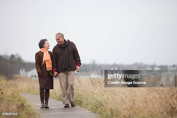 mature couple walking - mature couple winter outdoors stockfoto's en -beelden