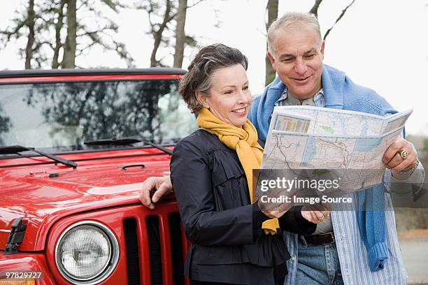 mature couple looking at map - mature couple winter outdoors stockfoto's en -beelden