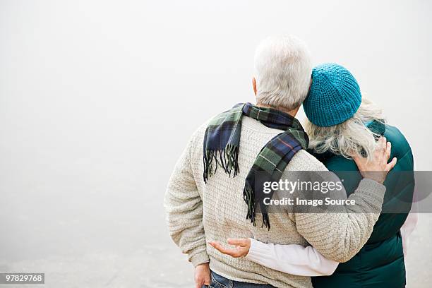 rear view of mature couple - arms around stockfoto's en -beelden