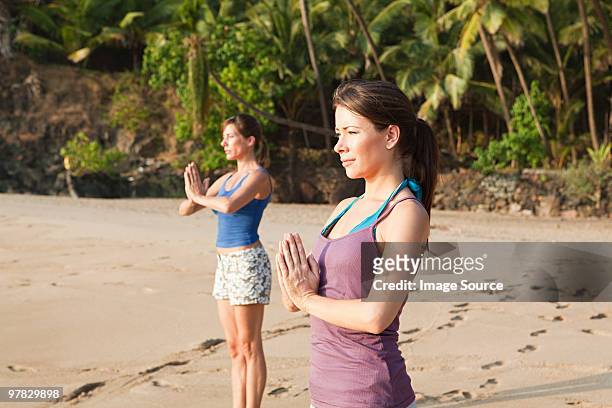 frau üben yoga am strand - sand art in india stock-fotos und bilder