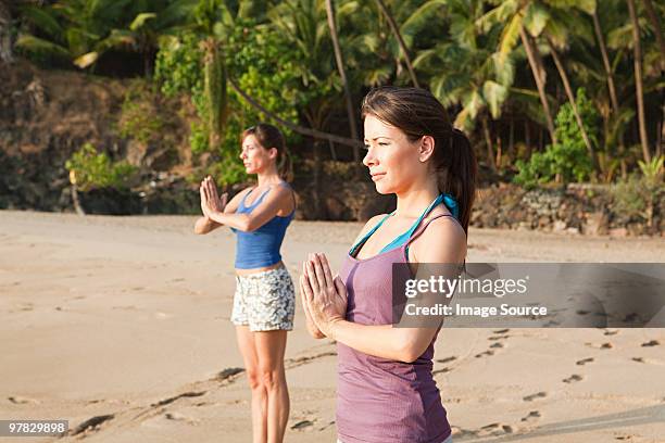 women practicing yoga on a beach - goa beach bildbanksfoton och bilder