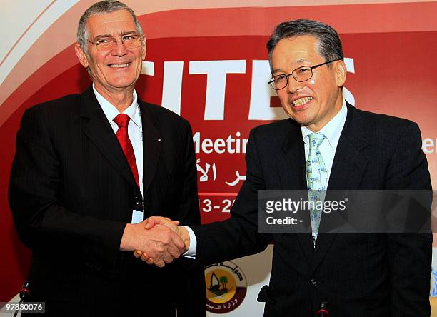 Masanori Miyahara, head of Japan's delegation and the country's top fisheries official, shakes hands with Patrick van Klaveren, head of the Monaco...