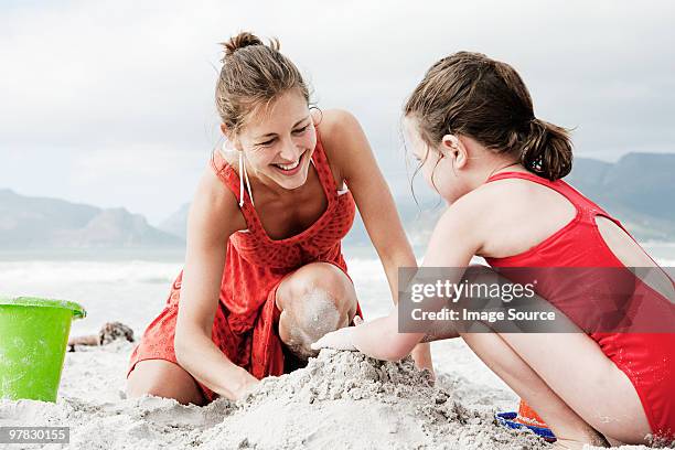 mother and daughter at the beach - beach bucket stock pictures, royalty-free photos & images