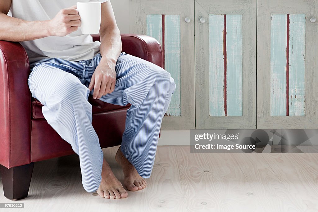 Man in pyjamas with cup of coffee