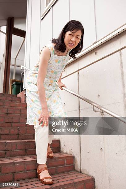 mature woman suffering from pain on knee - down on one knee fotografías e imágenes de stock