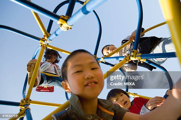 four children playing on jungle gym - jungle gym stockfoto's en -beelden