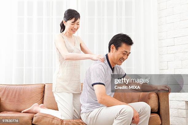 mature woman massaging mature man's shoulder - body massage japan stock pictures, royalty-free photos & images