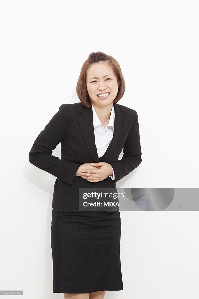 Young businesswoman suffering from stomachache