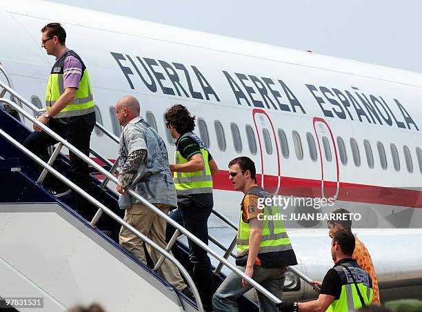 Spanish police officers custody a group of Spanish detainees accused of drug trafficking as they board the aircraft on their way back to Spain, at La...