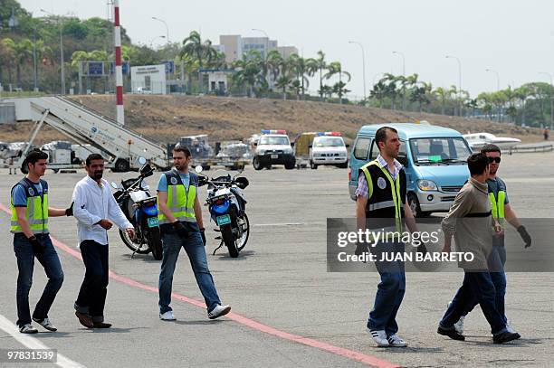 Spanish police officers custody a group of Spanish detainees accused of drug trafficking to board an aircraft on their way back to Spain, at La...