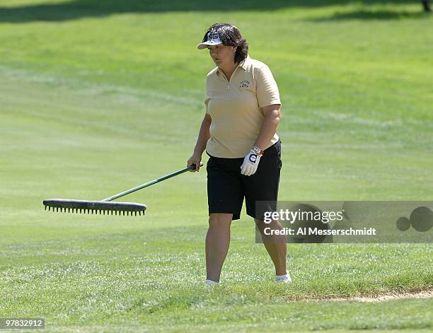 Pat Hurst carries a bunker rake on the sixth hole during the final round of the Safeway Classic at Columbia-Edgewater Country Club in Portland,...