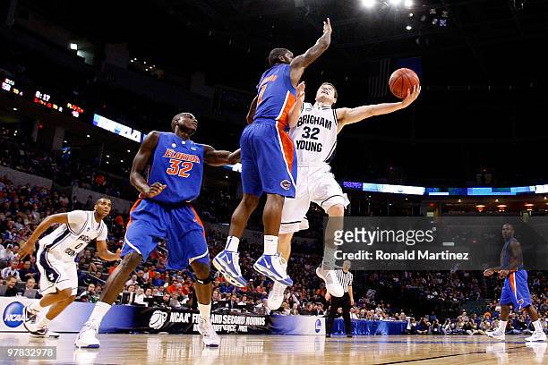Jimmer Fredette of the BYU Cougars drives for a shot attempt against Kenny Boynton of the Florida Gators during the first round of the 2010 NCAA...