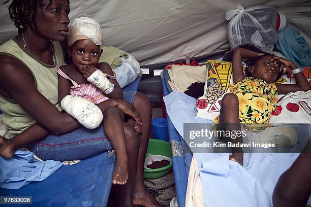 Yolad Joseph and her daughter Ashley and Wendia Similis , earthquake survivors, at the Red Cross medical observation tent inside General Hospital on...